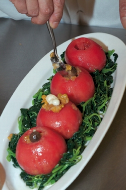 Place the blanched Chinese spinach flat on a dish and put the steamed tomatoes on top. Stuff the tomatoes with the fried mushrooms. Finally, pour the sauce made of thick chicken soup onto the tomatoes