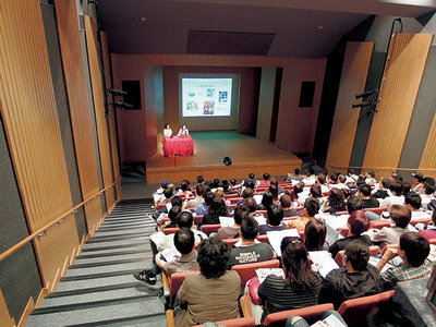 The participants give their full attention to the speaker's presentation.